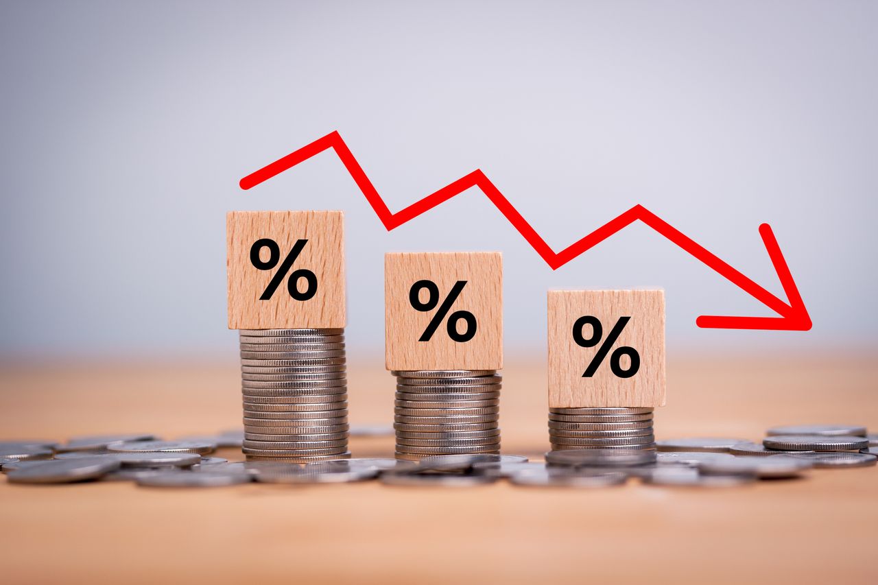 Percentage sign on wooden cubes with Stack of coin bar chart and red graph trending downwards on white background. Economy recession crisis, inflation, stagflation, business and financial loss concept