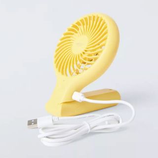 Yellow John Lewis handheld fan folded up with USB cord plugged in