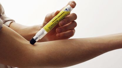 An epipen being used