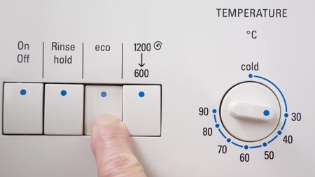 A finger turning a washing machine on