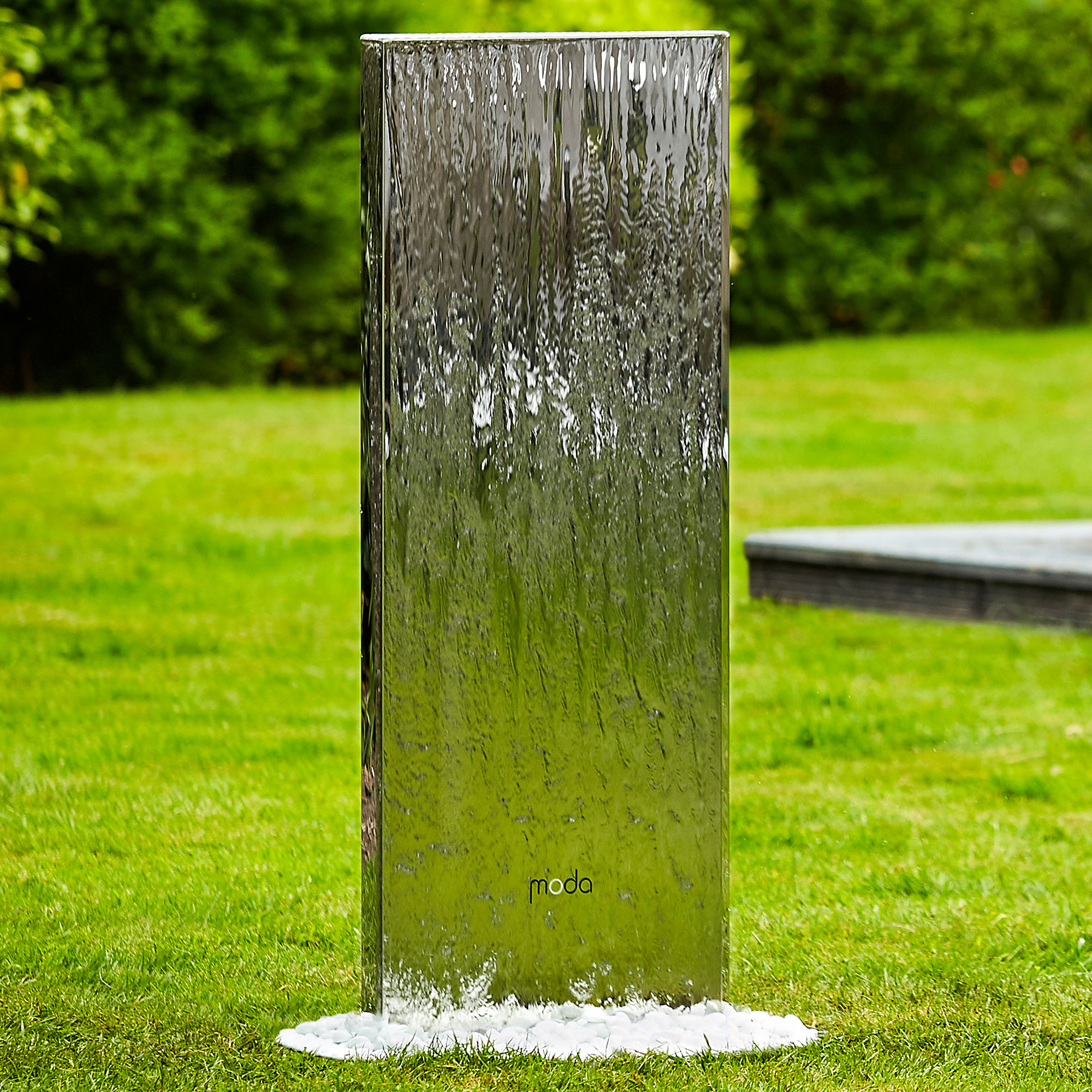 garden with grass lawn and metallic design water feature