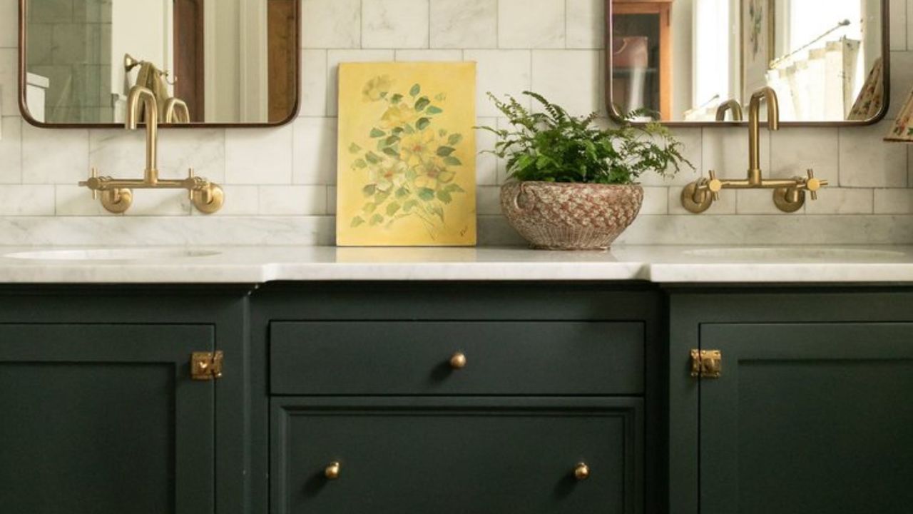 bathroom vanity painted in benjamin moore&#039;s black forest green with a marble countertop and brass tapware