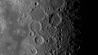 grey surface scattered with crater