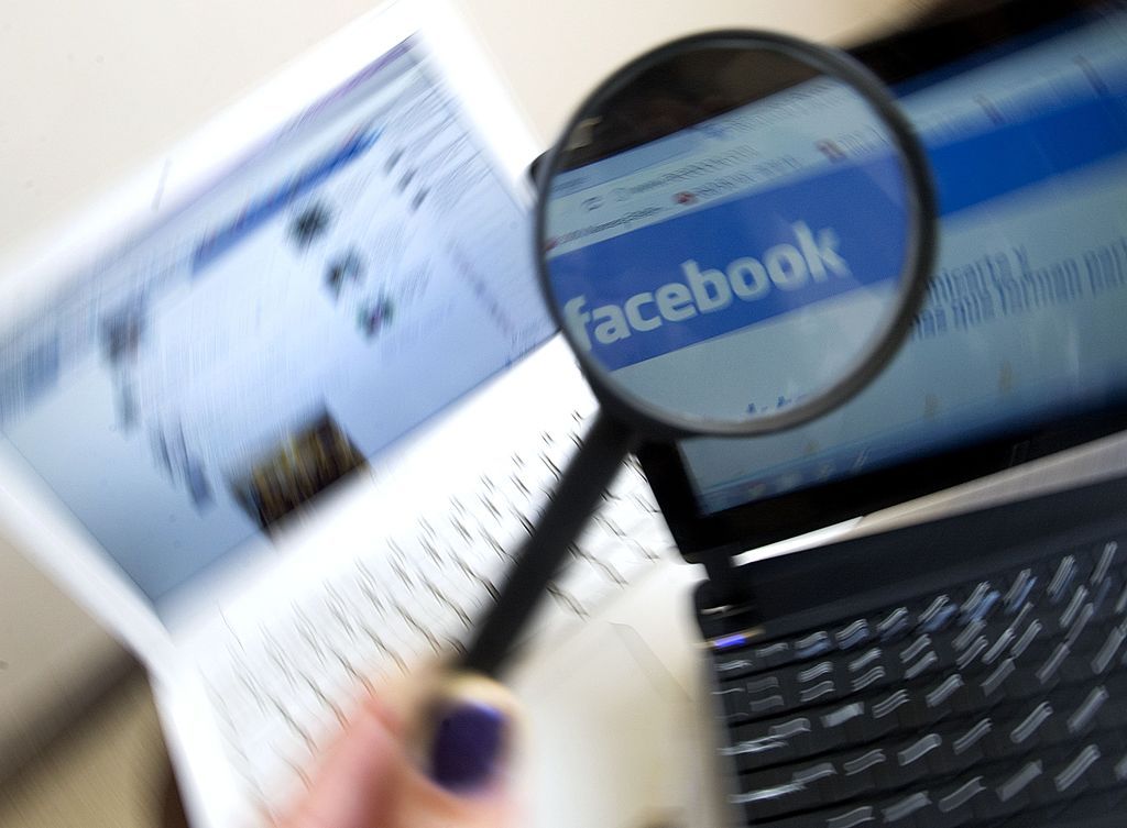 Facebook&amp;#039;s web logo viewed through a magnifying glass