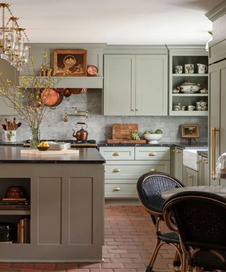 Cozy cottage kitchen with pale green kitchen cabientry and terracotta floor