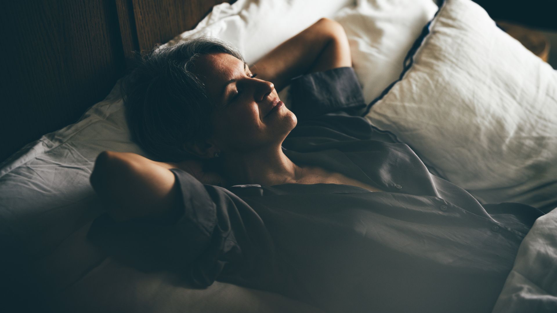 A woman relaxing in a cosy bed on her own