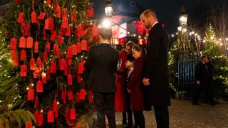 The Prince and Princess of Wales with their children Prince George, Princess Charlotte and Prince Louis look at messages on the Kindness Tree ahead of the Together At Christmas carol service at Westminster Abbey on December 6, 2024