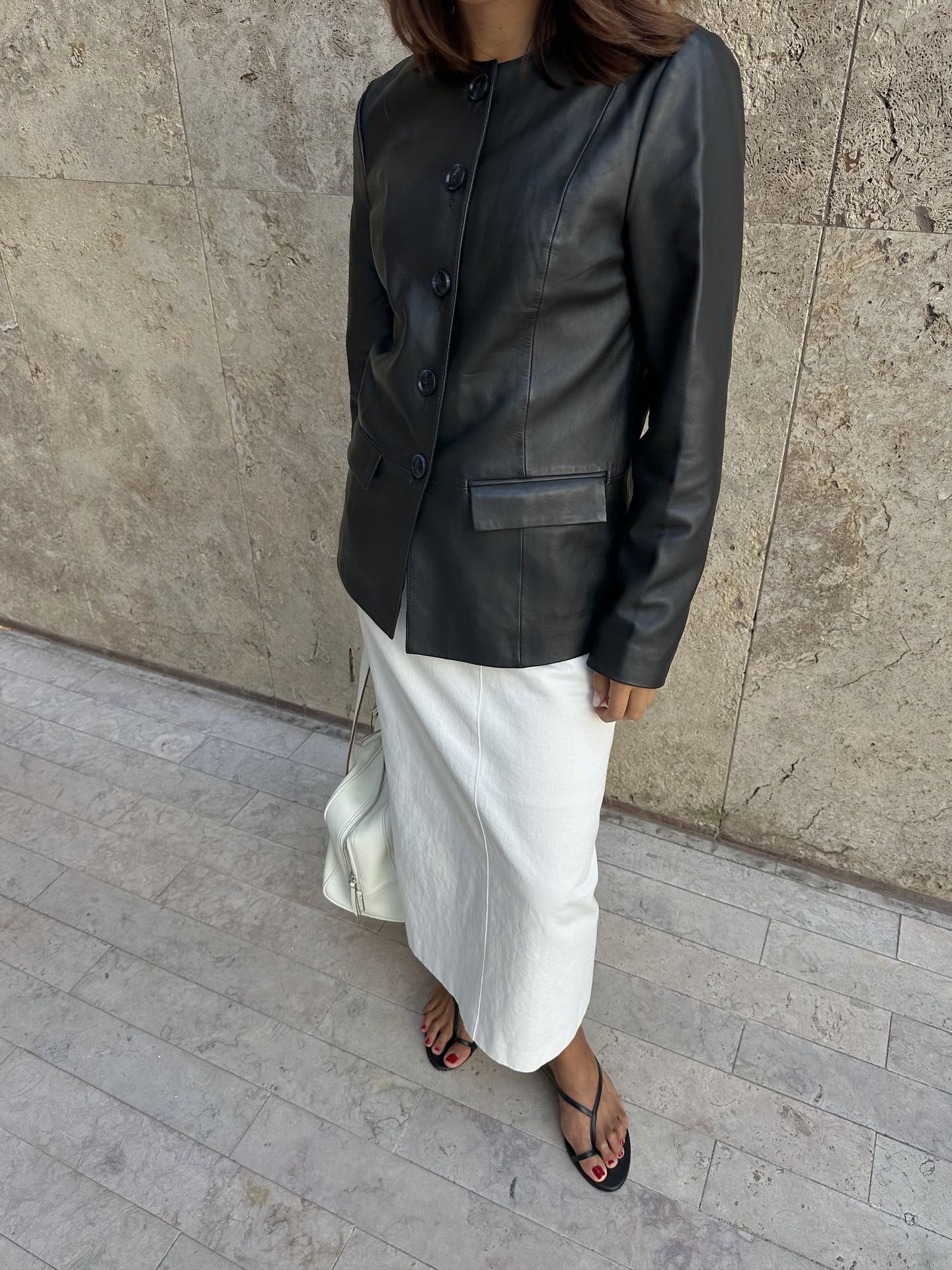 Photo of influencer wearing black leather collarless jacket.