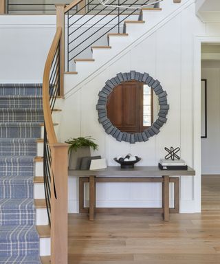 Gray and white entryway with circular mirror