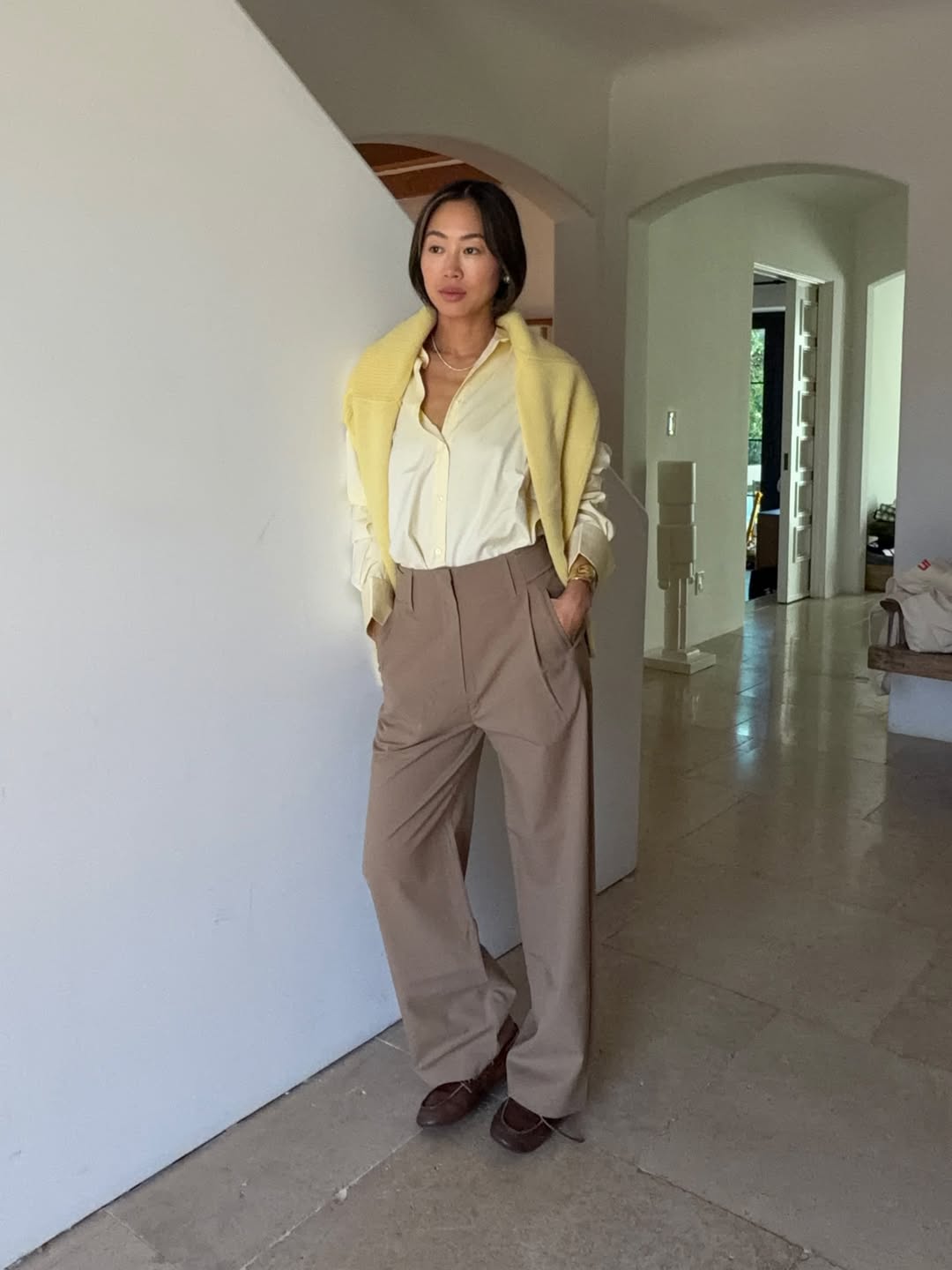 Aimee Song wearing a yellow pastel button-down shirt with trousers