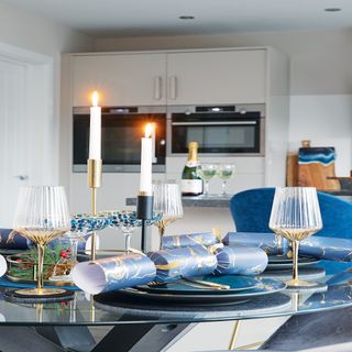 kitchen with white cabinets, glass dining room table with a candle on top