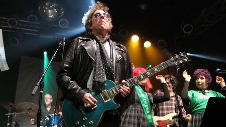 Ricky Byrd plays a green sparkle Les Paul onstage in 2011.