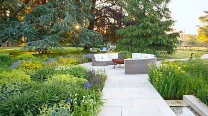 contemporary and sleek slab garden path leading to seating area in country garden