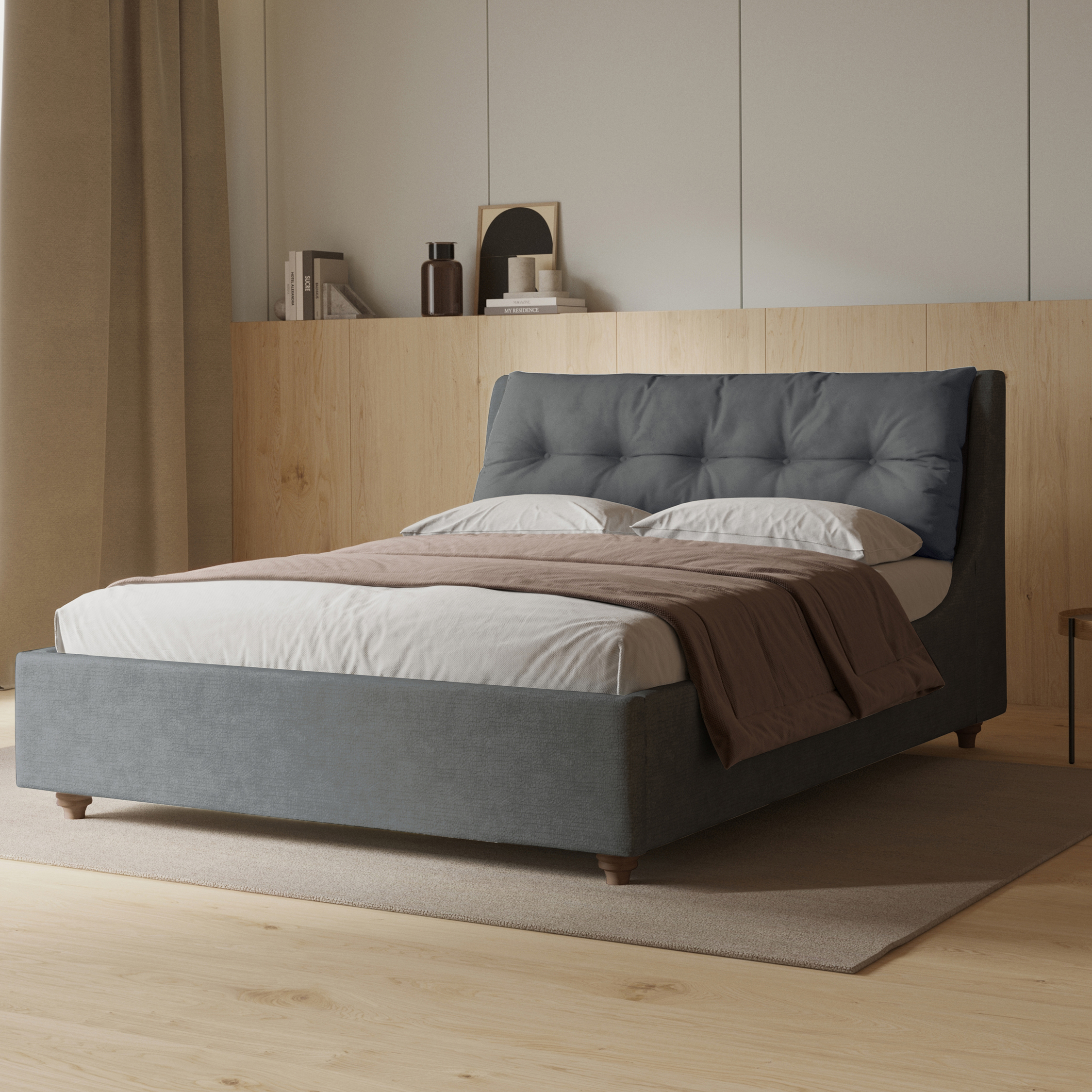 Grey upholstered bed with buttoned headboard in a modern bedroom with light wood panelled walls and floors