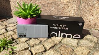 Das Realme GT Master Edition mit Verpackung, angelehnt an einen Blumentopf