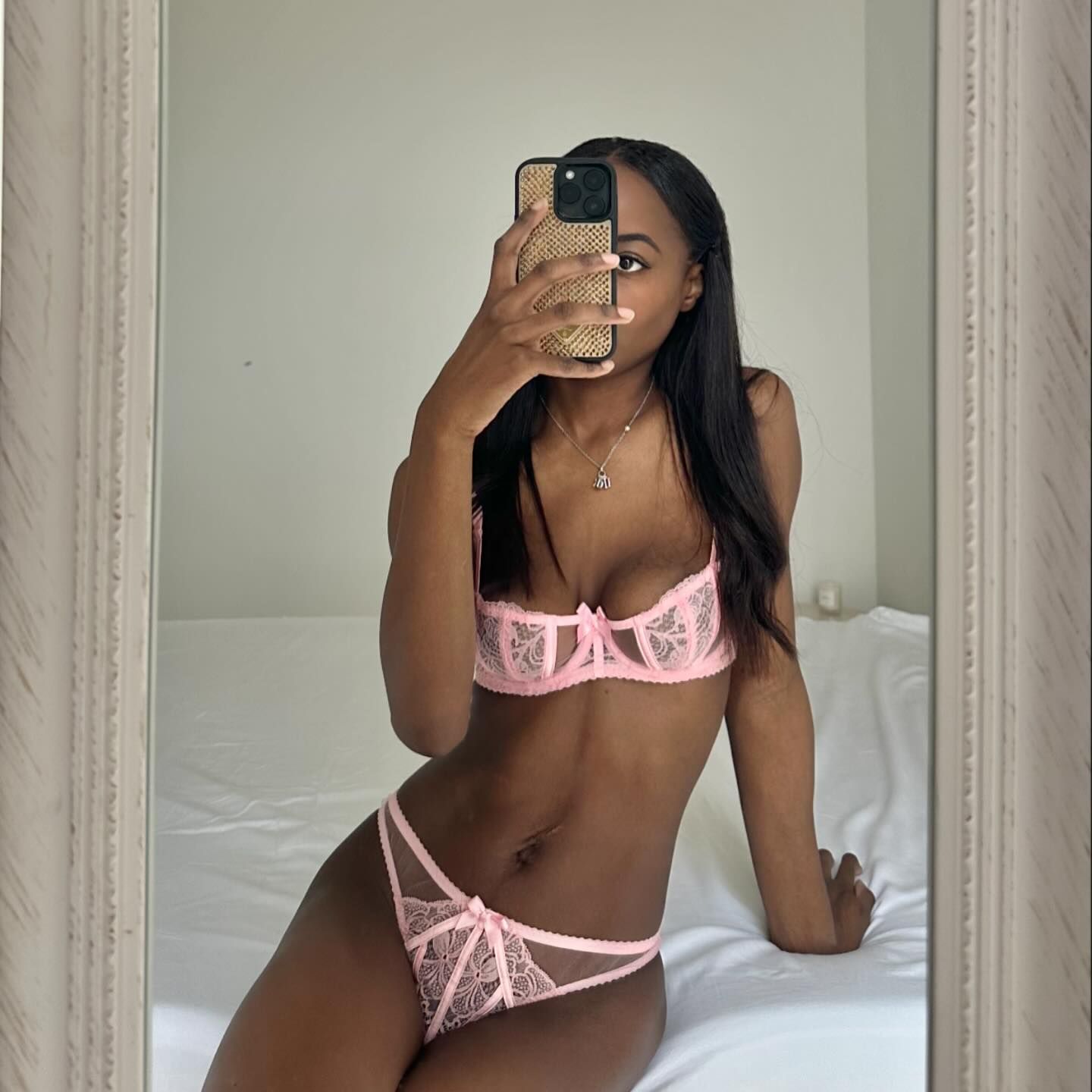 an influencer poses for a mirror selfie in a pink lace lingerie set from Agent Provocateur