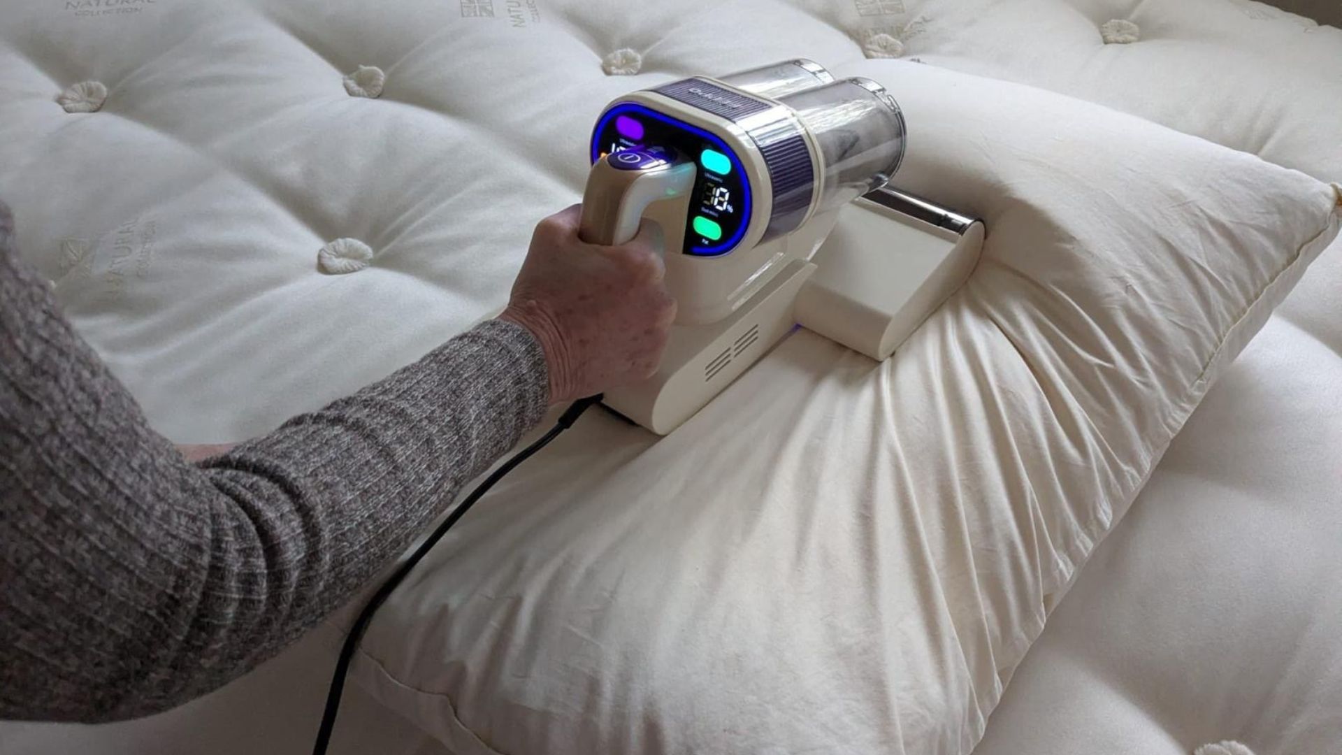 Our tester uses the white FEPPO Mattress Vacuum Cleaner to remove fine dust and particles from inside her mattress and pillow