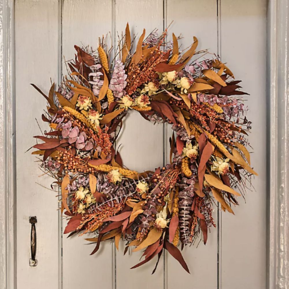 Fall wreath with dried flowers and foliage on a door