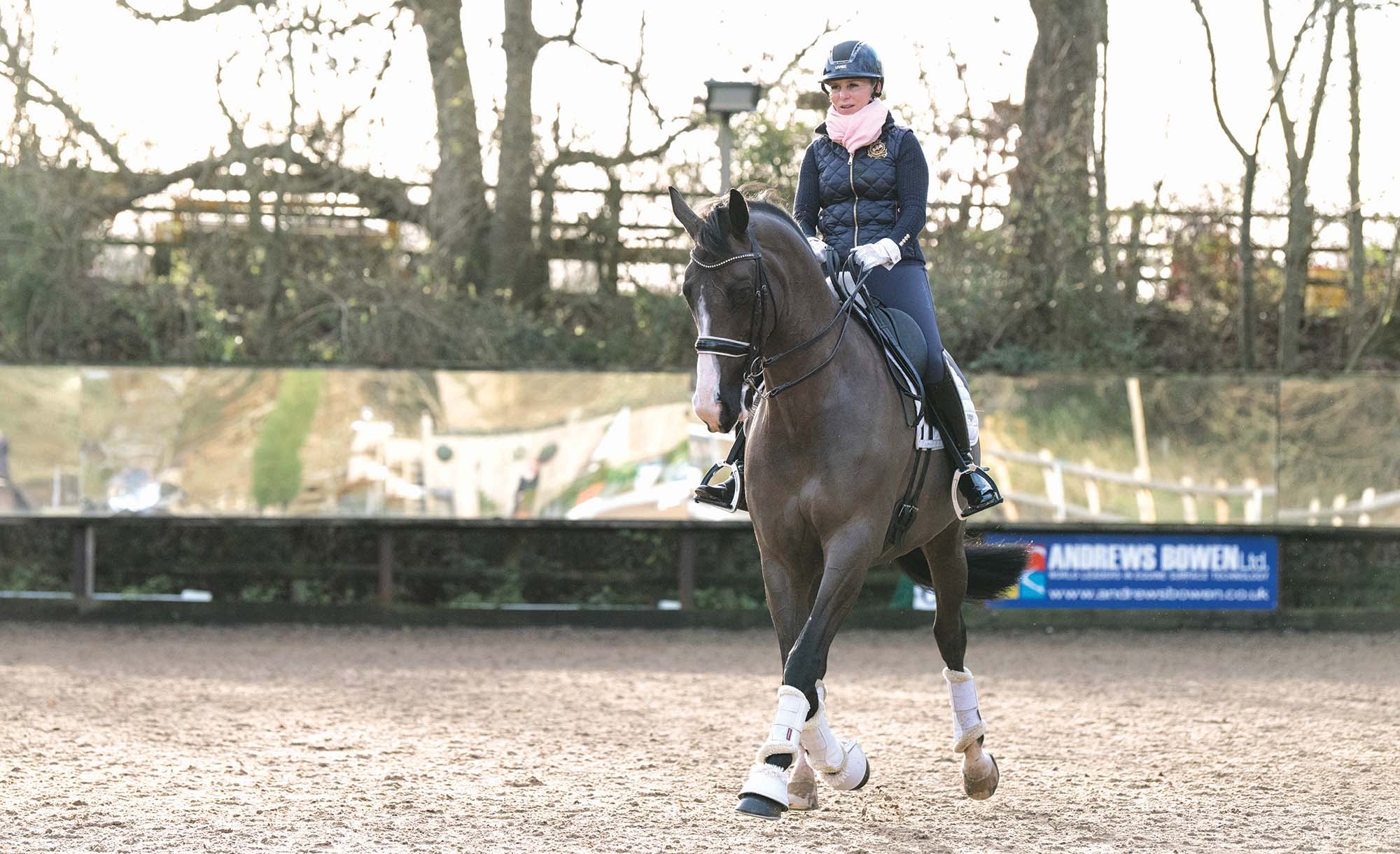 Louise Bell rides her dressage horse Peaky Blinder in trot at home during a magazine photo shoot.