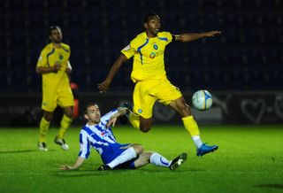 Wycombe Wanderers' Kevin Betsy rides the challenge of Colchester United's Steven Gillespie during a 2010 match