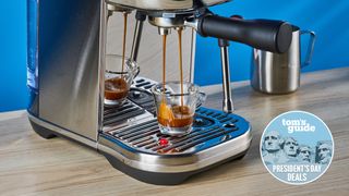 the breville bambino plus espresso machine shown pulling a shot of caramel espresso with a tom's guide presidents' day deal badge
