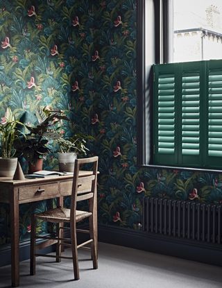 Room with desk and chair, patterned wallpaper and shutters