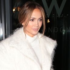 Jennifer Lopez wears a white turtleneck dress and a white furry coat