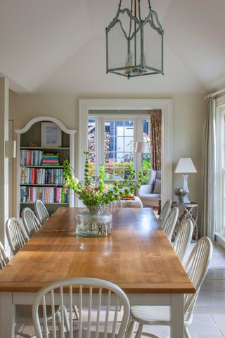 dining room with bookshelf, curtains and flowers on the tbale