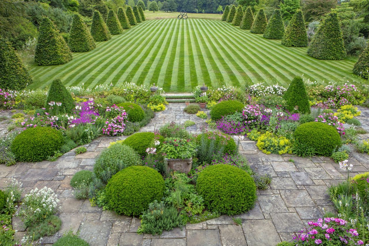 ROCKCLIFFE GARDEN, GLOUCESTERSHIRE: PATIO, TERRACE, STRIPED, STRIPES IN LAWN, BEECH OBELISKS, LA