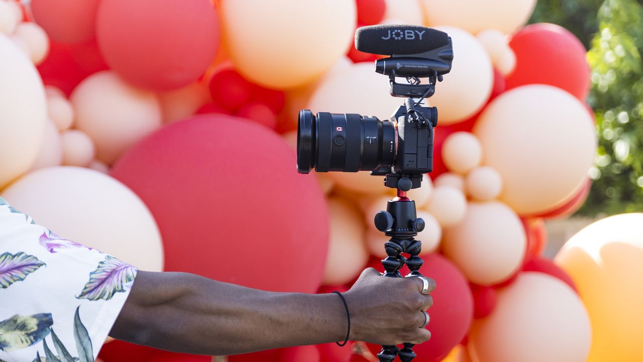 Arm of a person holding a mirroless camera with a JOBY Wavo PRO mounted on it