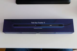 En förpackning till Tobii Eye Tracker 5 ligger på ett vitt skrivbord.