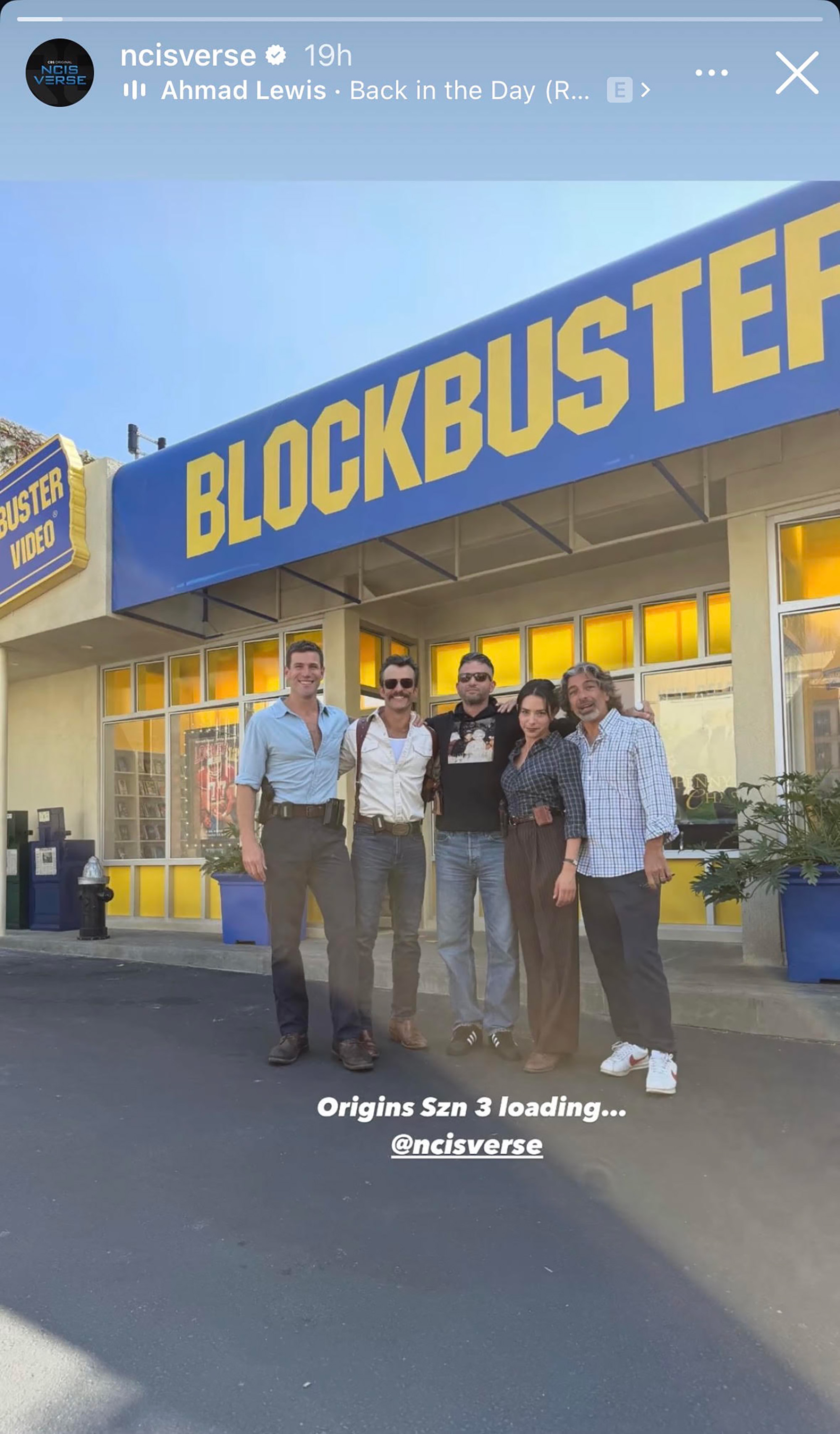 A photo from the set of Season 3 of NCIS: Origins outside of a Blockbuster video set to look like the 1990s.