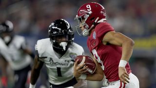 Quarterback Bryce Young of the Alabama Crimson Tide is chased out of the pocket by Ahmad Gardner of the Cincinnati Bearcats during the Goodyear Cotton Bowl Classic for the College Football Playoff semifinal game on December 31, 2021 in Arlington, Texas.