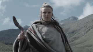 Faye Marsay as Vel Sartha trudging down a mountain with a walking stick on Andor