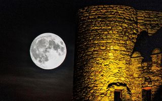 A full moon rises by Cassis castle in France on Aug. 25, 2018.