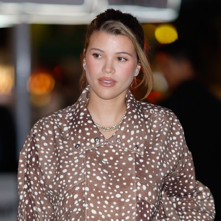 Sofia Richie wears a brown animal print jacket and has a blonde streak in her hair, which she wears tied back