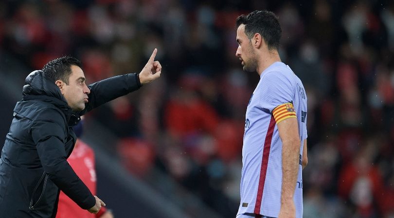 Xavi gives instructions to Sergio Busquets during a Barcelona game.