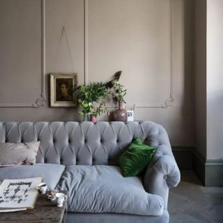 A beige room with a gray couch