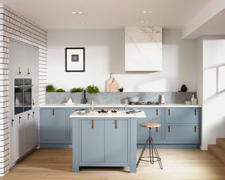 Light and airy modern kitchen with soft blue cabinets and island and white tiled feature wall