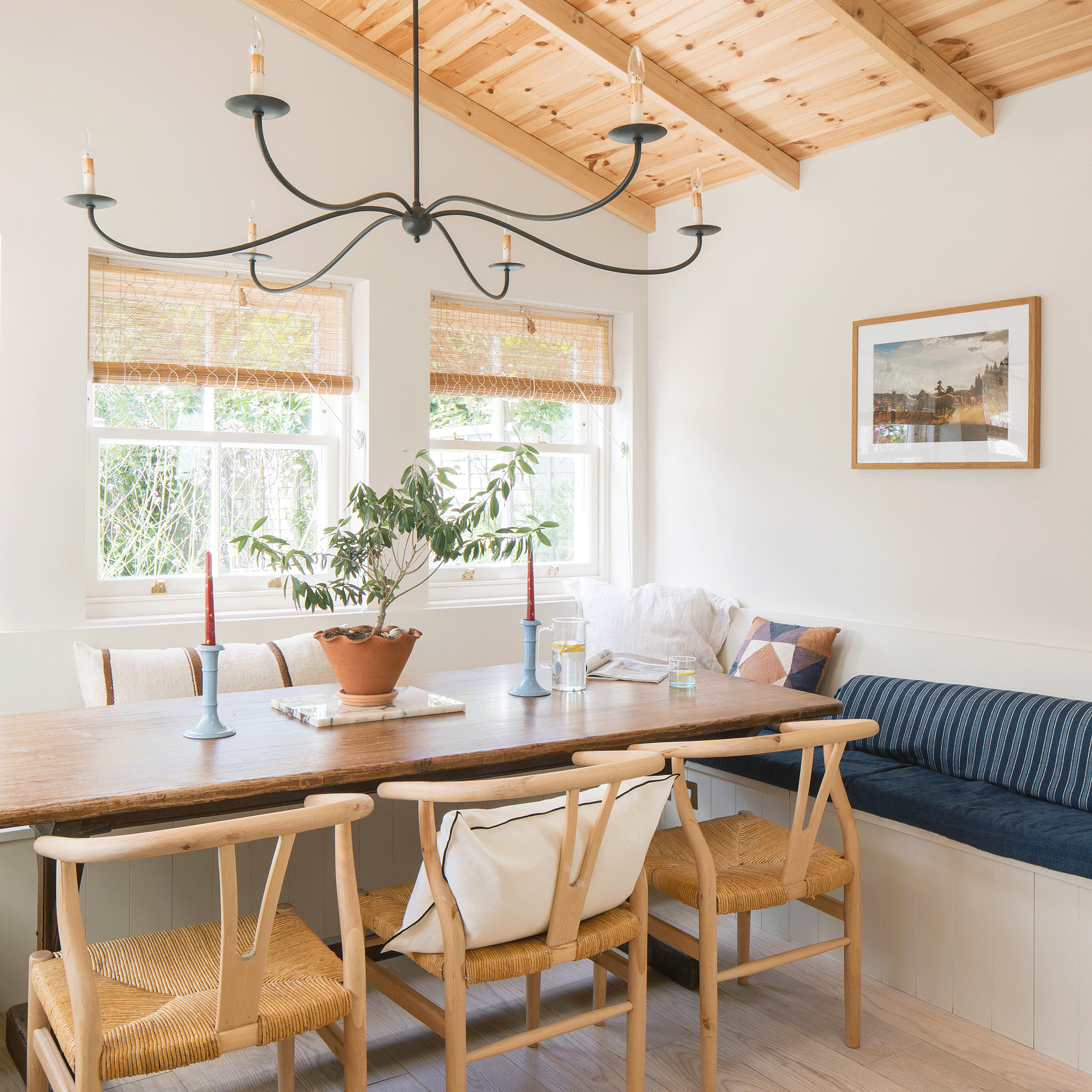 a corner dining area with banquette seating and a wooden clad ceiling