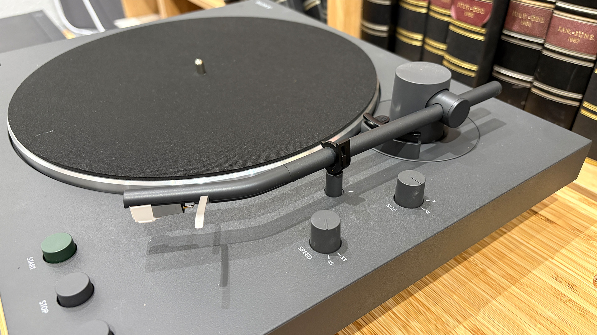 Sony PS-LX3BT Bluetooth turntable on wooden hi-fi rack, close up on tonearm