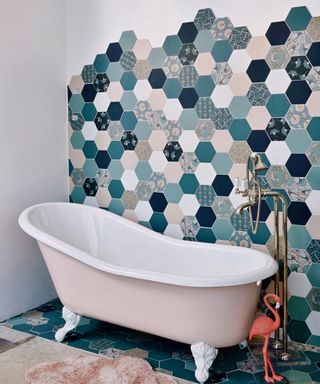 Blue patchwork effect tiles in bathroom going from floor and up wall with distorted border effect.