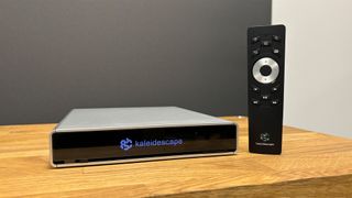 Kaleidescape Strato C and Terra Prime 8TB SSD showing Strato C with remote on wooden bench