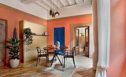 Francesca Venturoni's dining area featuring a round dining table, blue doors and white curtains