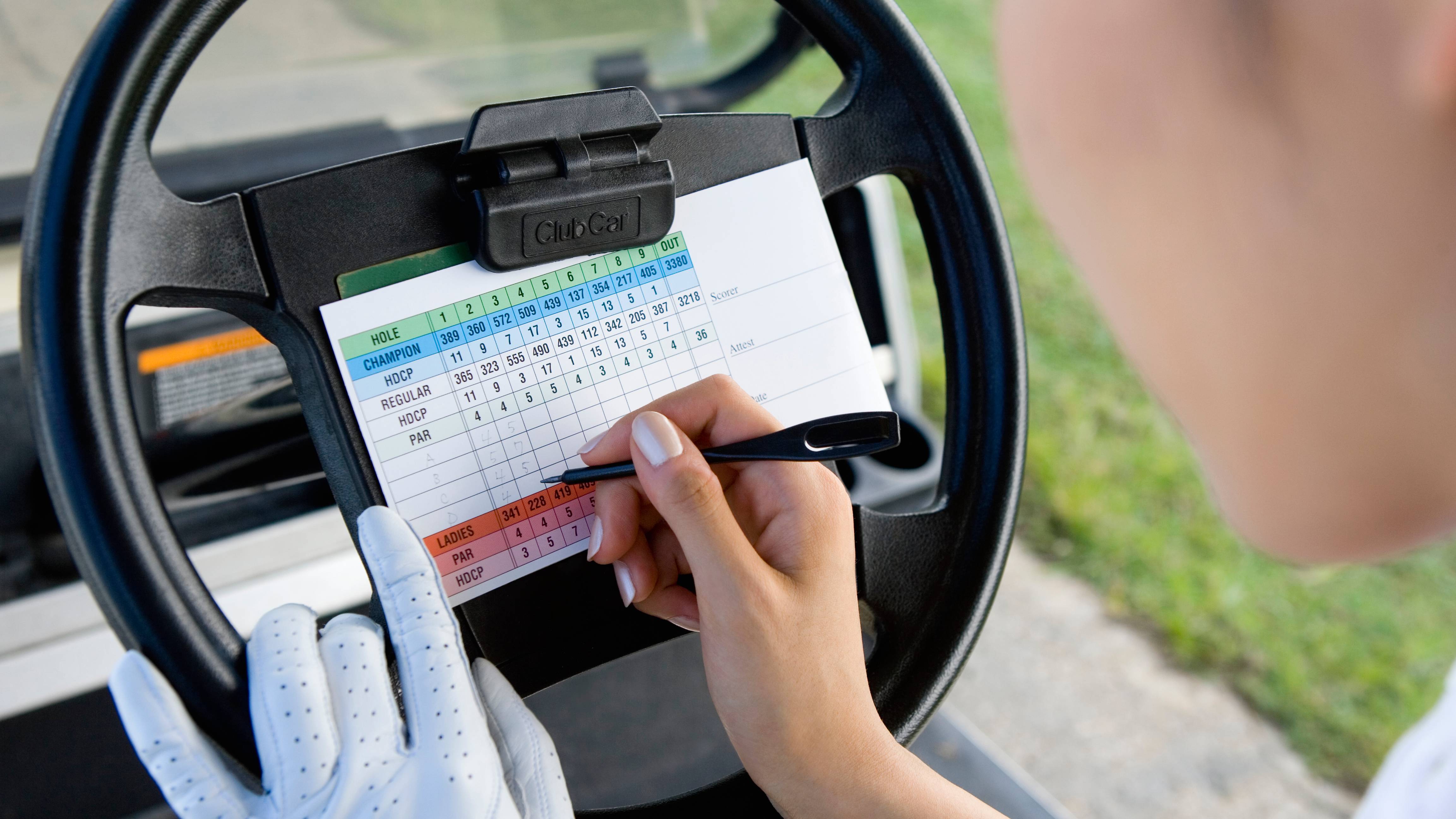 Female golfer marking a scorecard