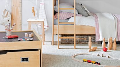 A childrens bedroom with a wooden bunk bed, wooden toy box and wooden skittles and toy train track in shot