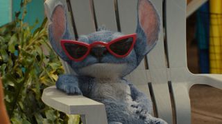 Stitch sits back confidently while wearing sunglasses in Lilo & Stitch.