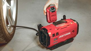 Craftsman V20 Cordless Tire Inflator next to car tire
