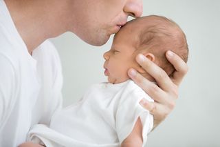 A stock photo of a man kissing a baby.