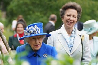 Queen Elizabeth II and Britain's Princess Anne, Princess Royal gesture during a visit to The Childrens Wood Project in Glasgow on June 30, 2021